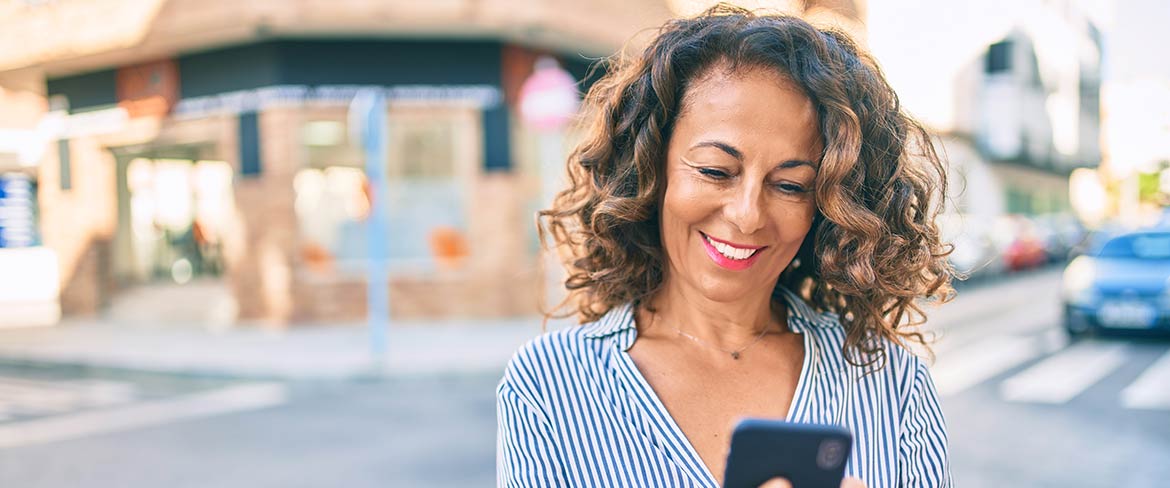 Smiling woman looking at mobile phone